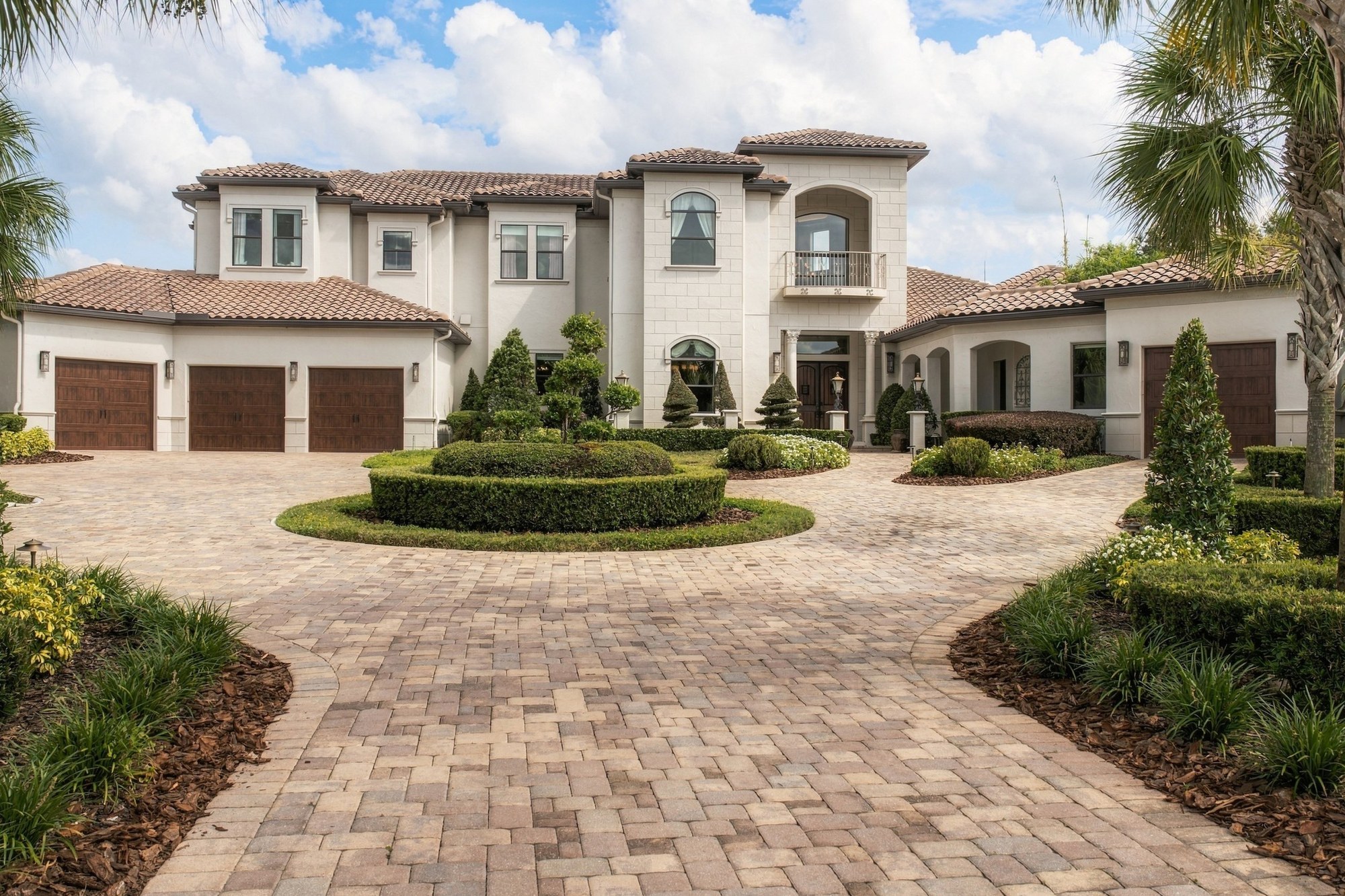 Mediterranean-style estate with a tile roof and a paver motor court